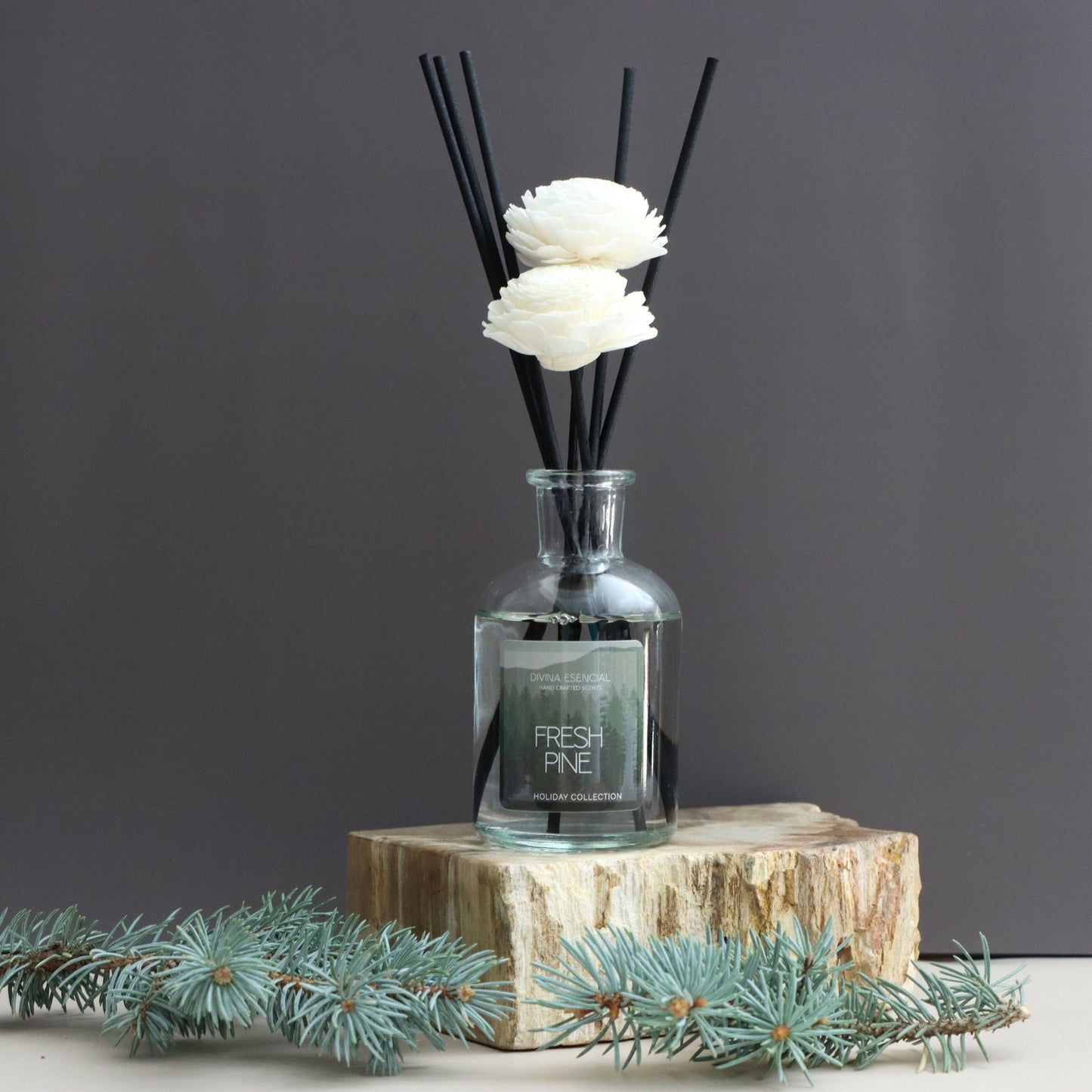 Diffuser with black reeds and white flowers on a gray background