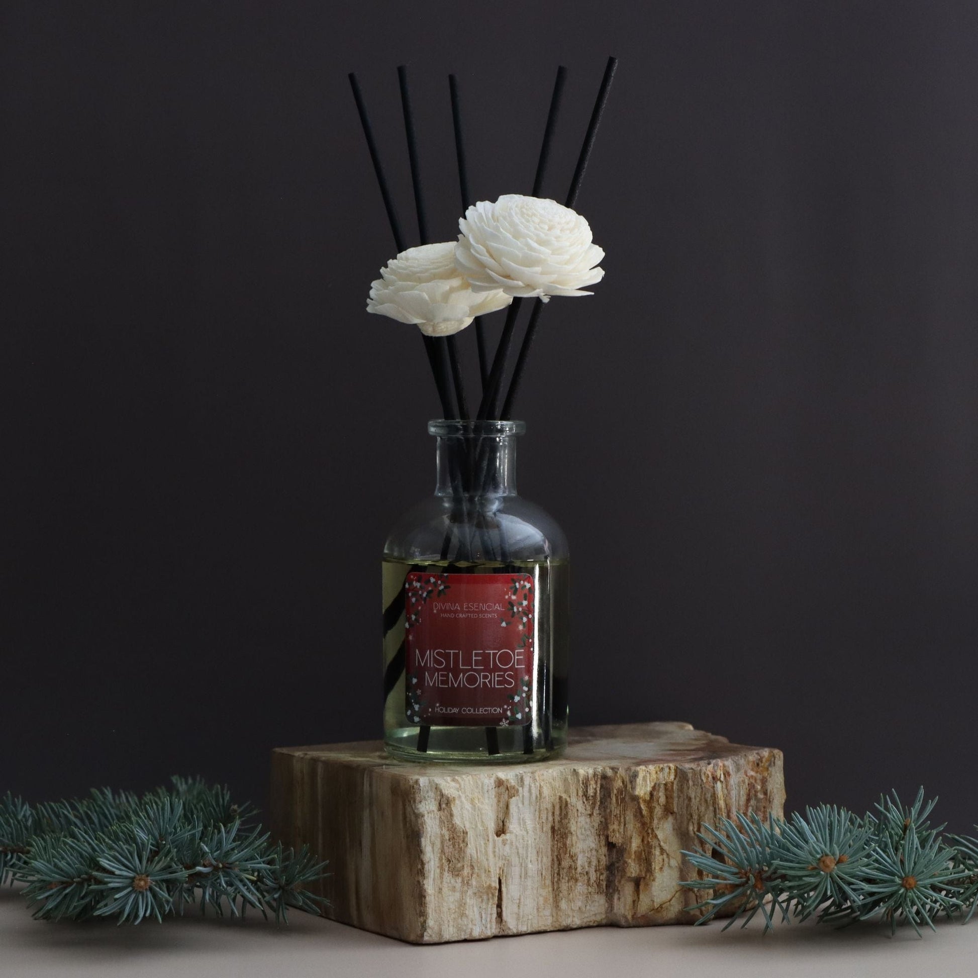 Reed diffuser with white flowers on a dark background