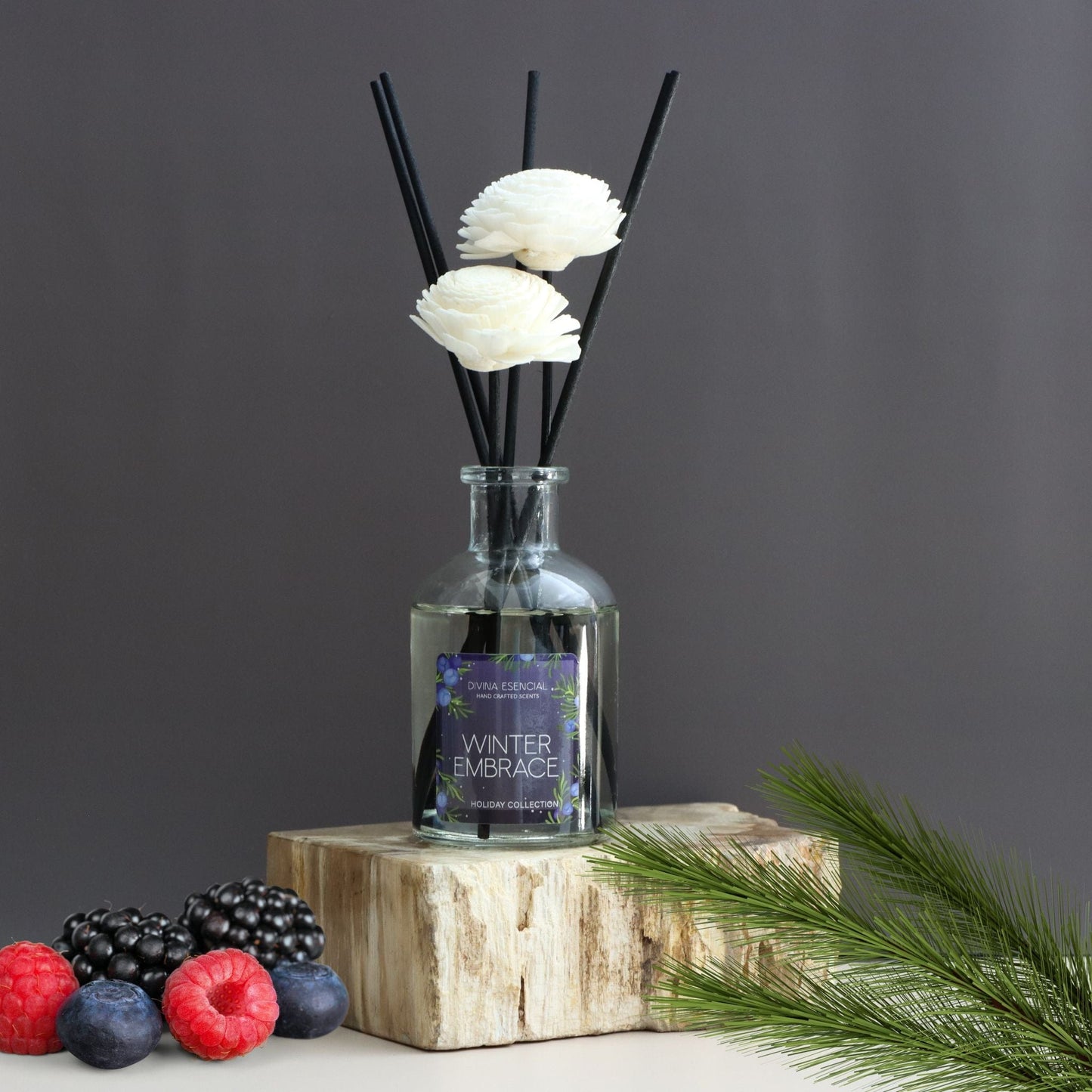 Diffuser with floral elements on a wooden block against a dark background