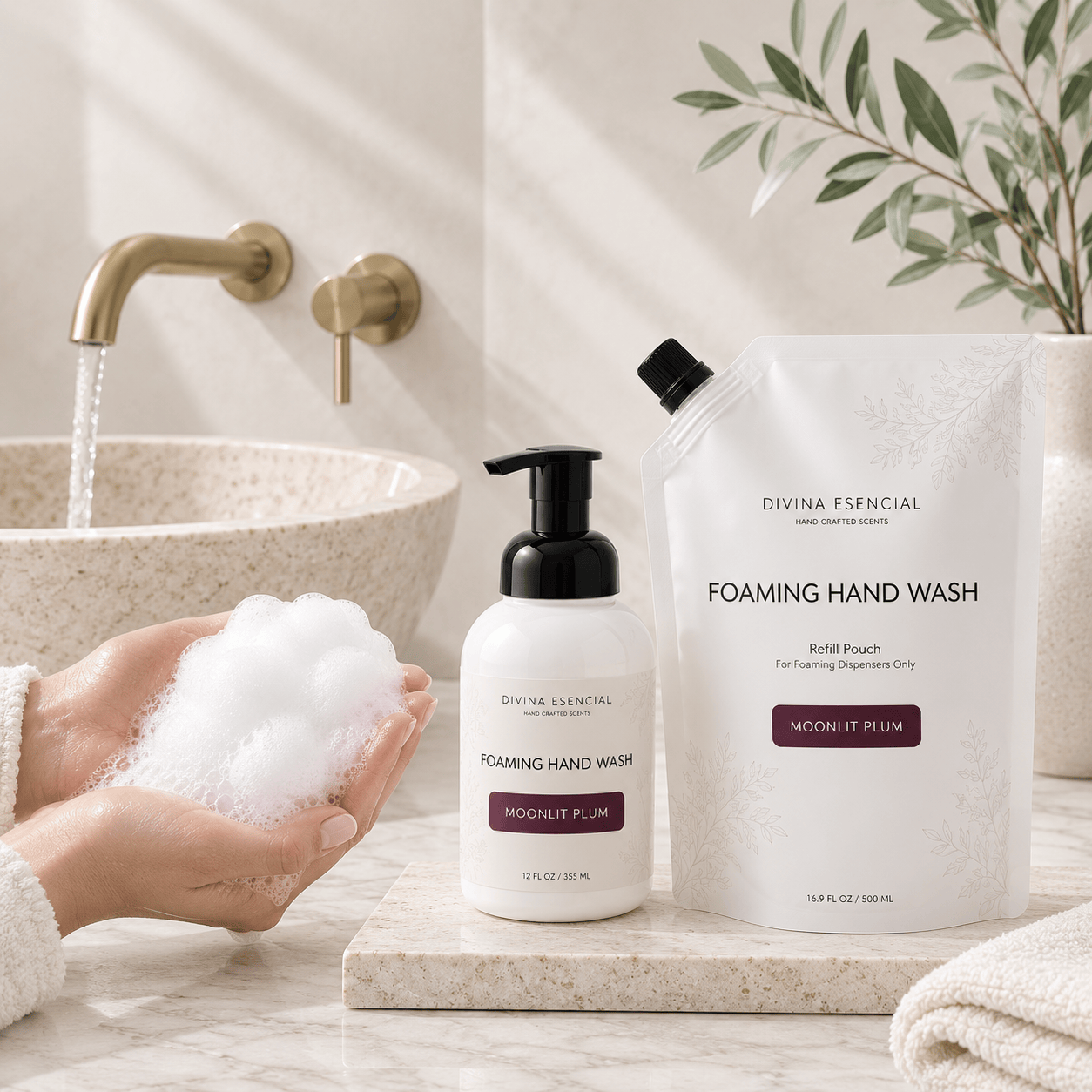 Divina Essential Foaming Hand Wash set in a bright bathroom setting, featuring a white pump bottle with a black pump and a matching refill pouch on a marble tray next to a sink with running water and a hand holding foam.