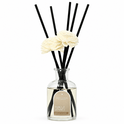 Diffuser with black sticks and white flowers in a clear bottle on a white background