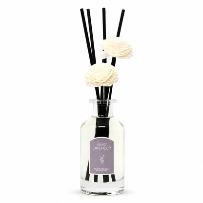 Diffuser with black reeds and white flowers labeled 'Velvet Lavender' on a white background